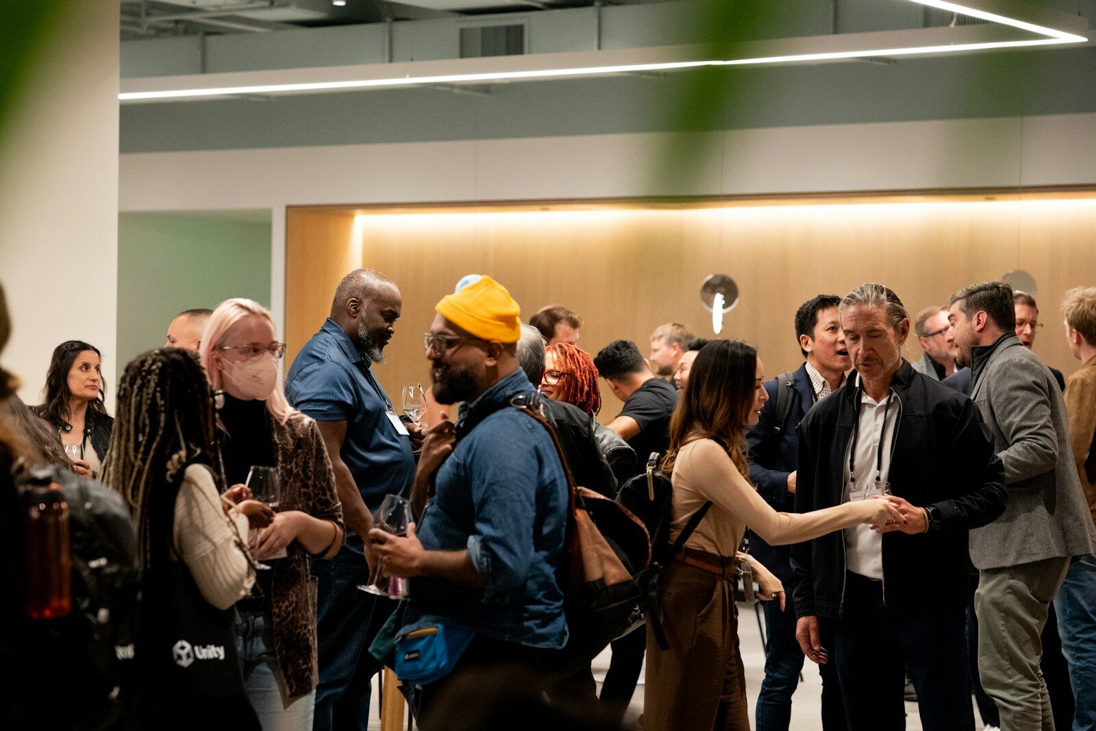 People mingling at an indoor event with warm lighting.
